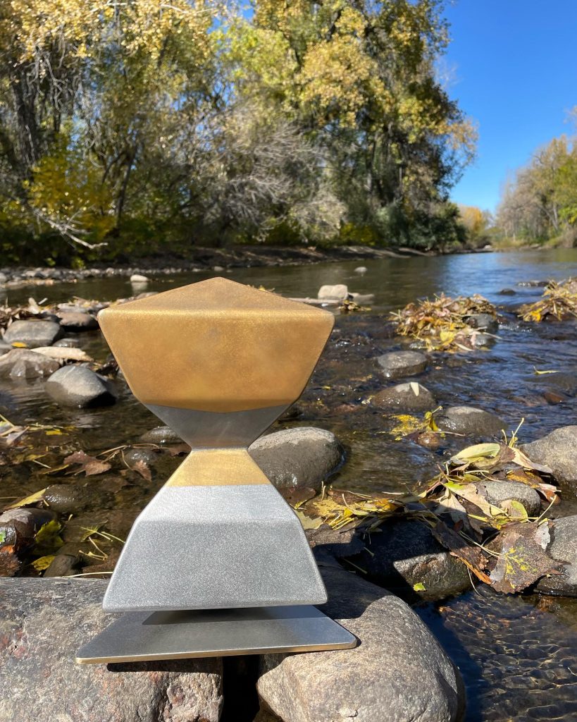 Gold and silver steel sculpture by the river